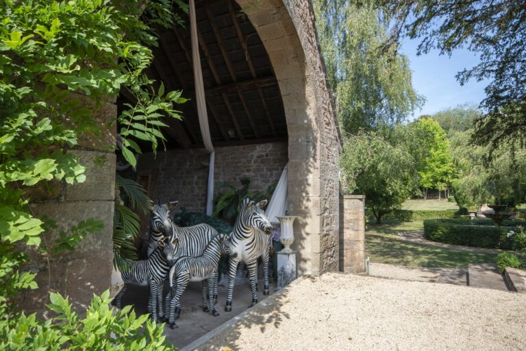 Zebra models sheltering under the stone arch of the barn, looking out over the garden, Tan House Newland