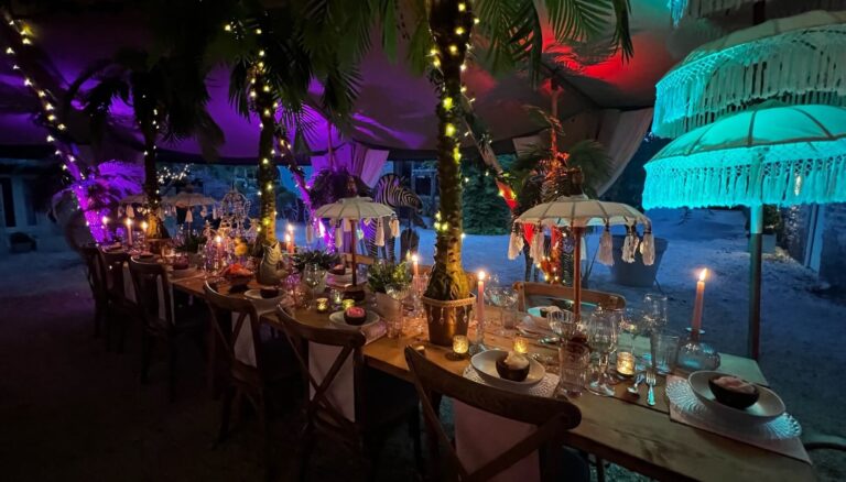 Candlelit tables under parasols and strings of lights in the teepee after dark, Tan House Newland
