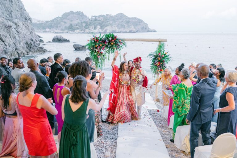 A South Asian ceremony on the shingle beach below Taormina, the headland behind, Taormina Weddings