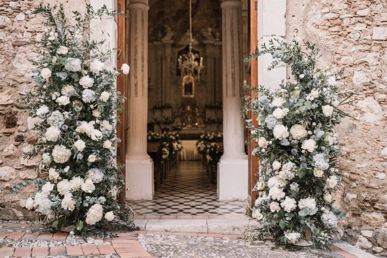 Two pillars of white roses and hydrangea framing a church door, Taormina Weddings