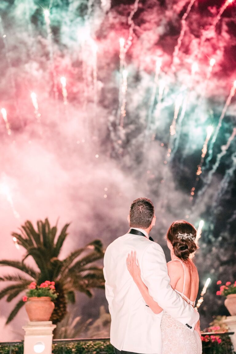 The couple watching a firework finale from a terrace, Taormina Weddings