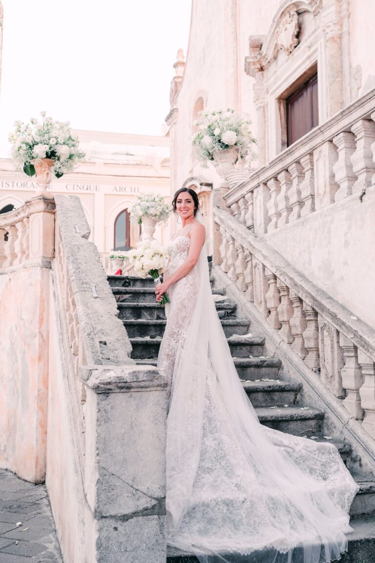 The bride on a baroque church staircase with white flower urns, Taormina Weddings