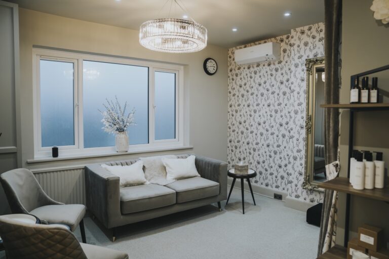 The Forever suite with a sofa under a window, floral wallpaper and a shelf of toiletries, TDR Bridal
