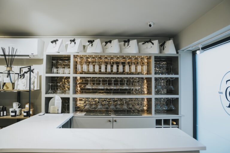 The boutique bar with a white counter, shelves of glassware and ribboned gift bags, TDR Bridal