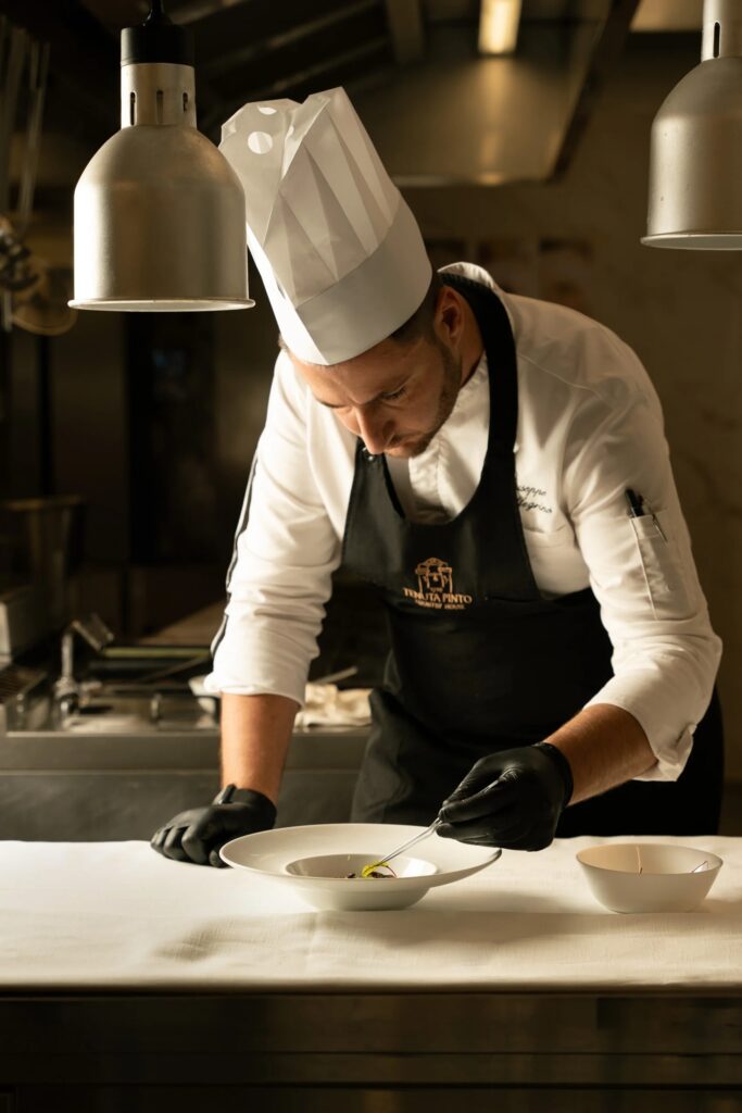 A chef plates a dish in the Tenuta Pinto kitchen, Tenuta Pinto