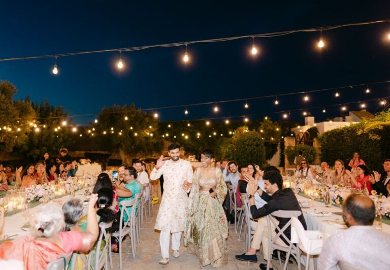 The couple enter dinner under string lights in the courtyard, Tenuta Pinto