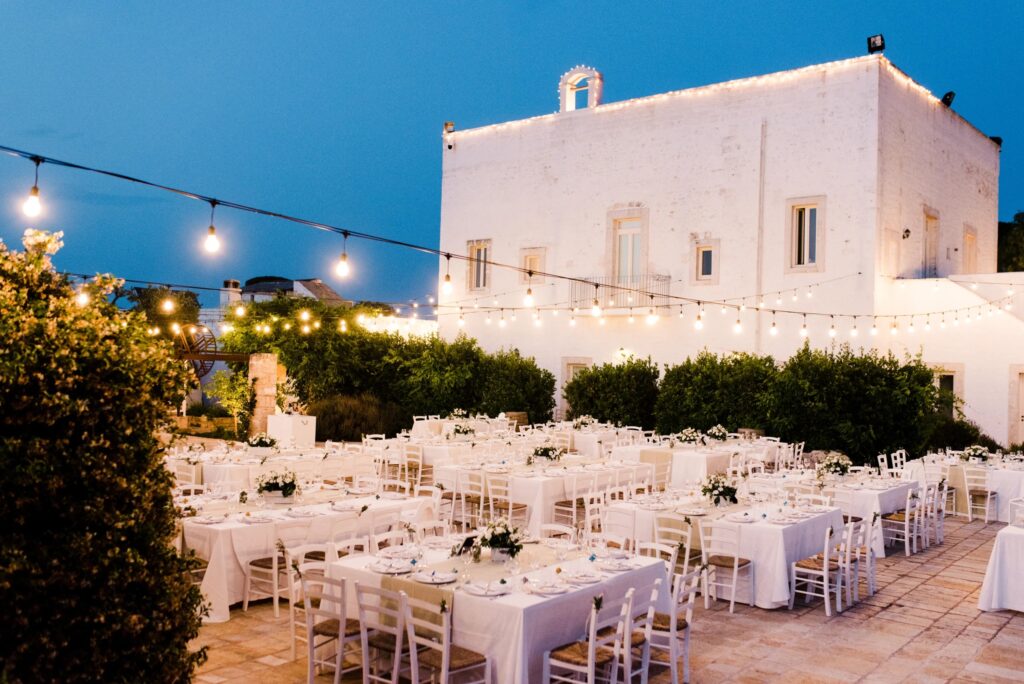 A reception set out at dusk in the courtyard beside the masseria, Tenuta Pinto