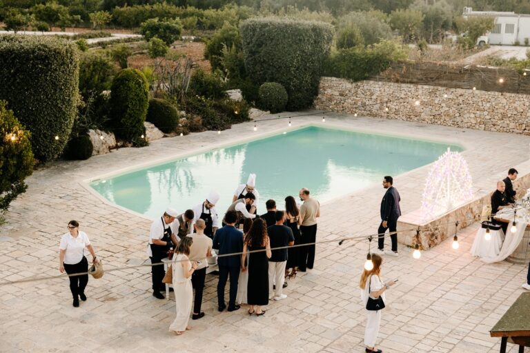 Guests gather beside the pool in the walled garden at an event, Tenuta Pinto