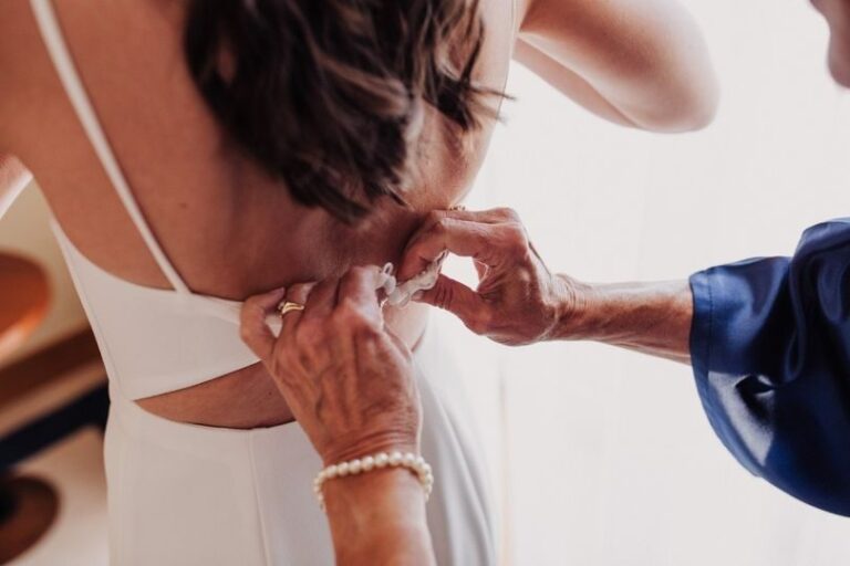 Close detail of hands fastening the bride's necklace on the morning of the wedding, TFY Weddings