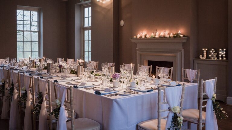 A long table laid for a smaller wedding breakfast beside a candlelit fireplace, That Amazing Place