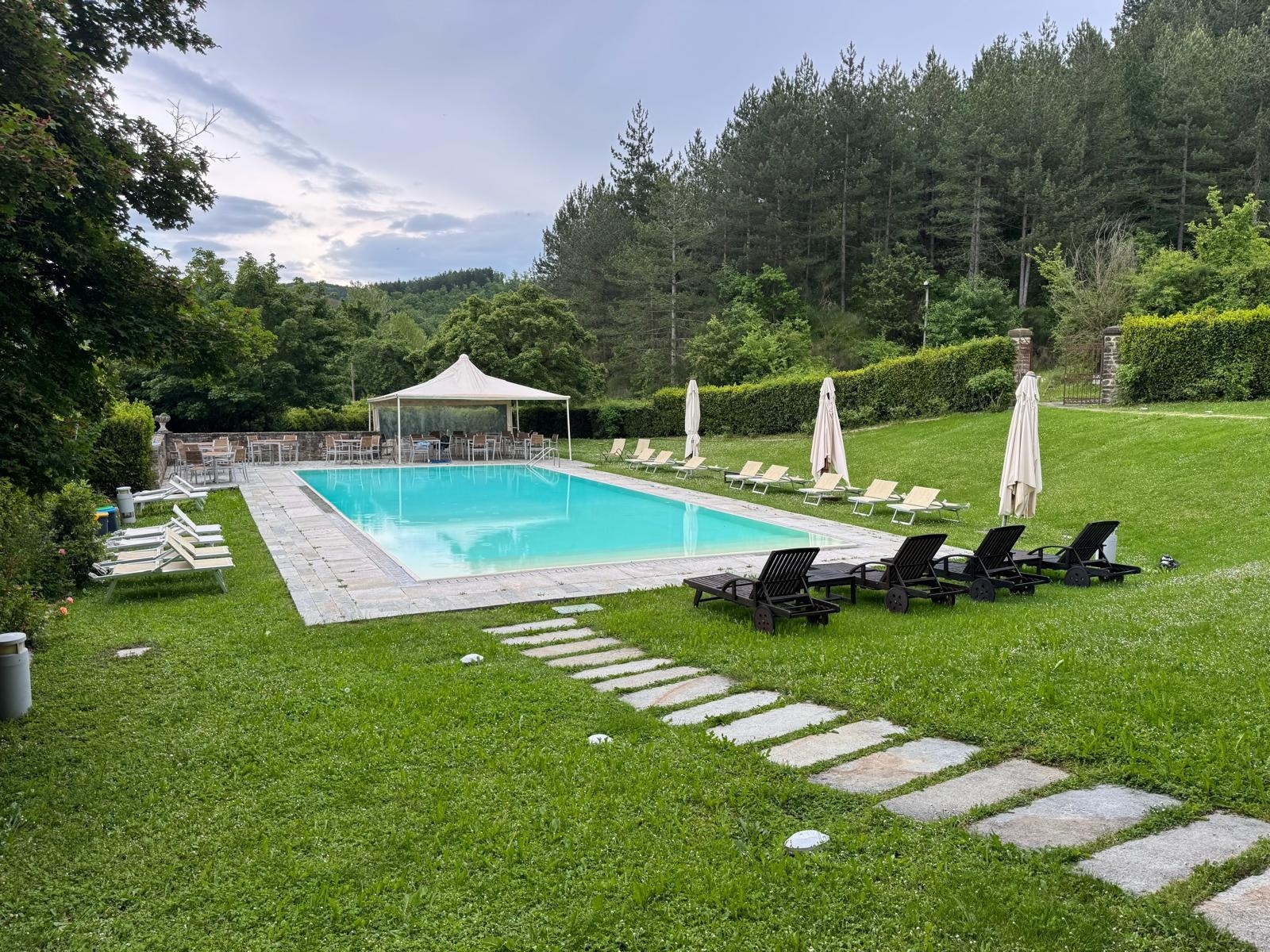 The pool, sun-loungers and stone paths in the park above the valley, The Abbazia San Faustino