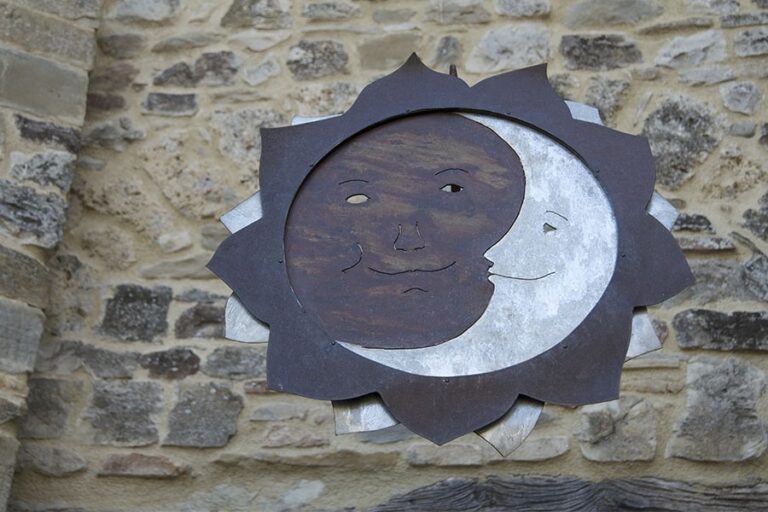 A carved sun and moon set into the ancient stone of the abbey, The Abbazia San Faustino
