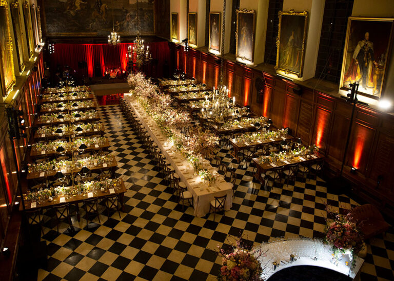 Aerial view of banquet tables in a great hall with a chequered floor, The Admirable Crichton