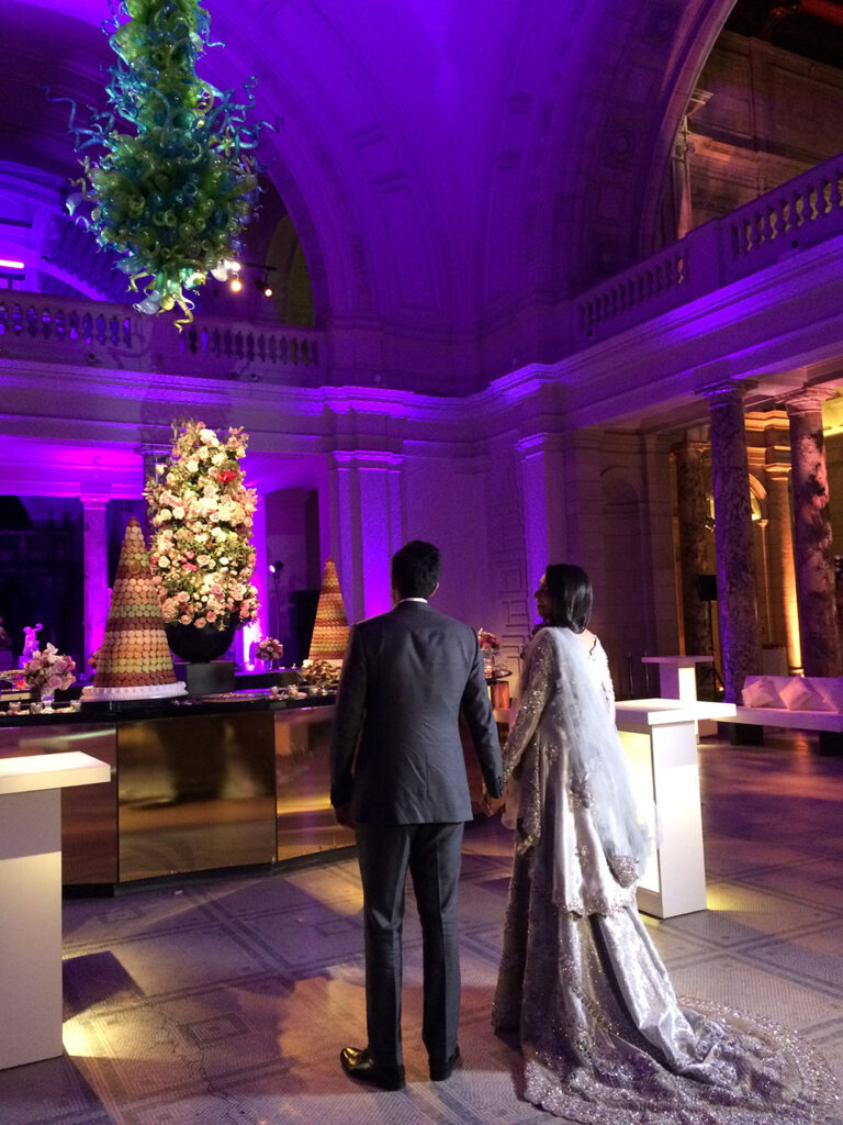Couple in a candle and violet-lit stately room set for the reception, The Admirable Crichton