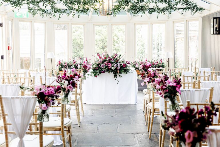 The Conservatory dressed for a civil ceremony with magenta and blush florals, The Bay Tree Hotel