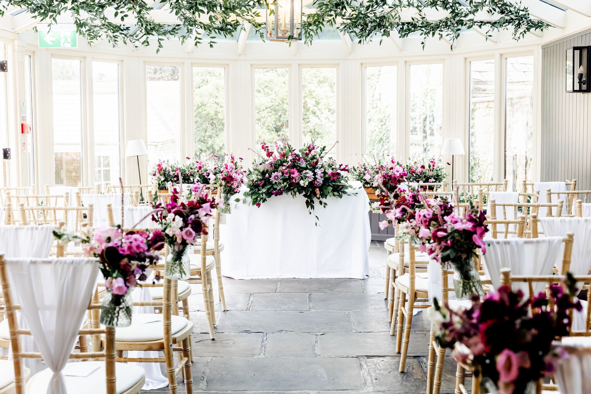 The Conservatory dressed for a civil ceremony with magenta and blush florals, The Bay Tree Hotel