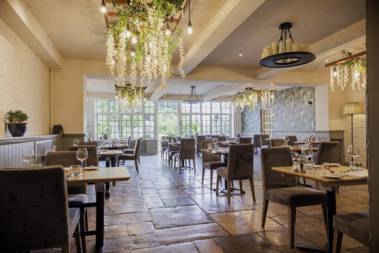 The Conservatory restaurant, flagstone floor, hanging blossom and festoon lighting, The Bay Tree Hotel