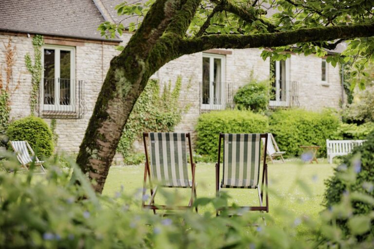 Deckchairs on the lawn beneath a mature tree in the walled garden, The Bay Tree Hotel