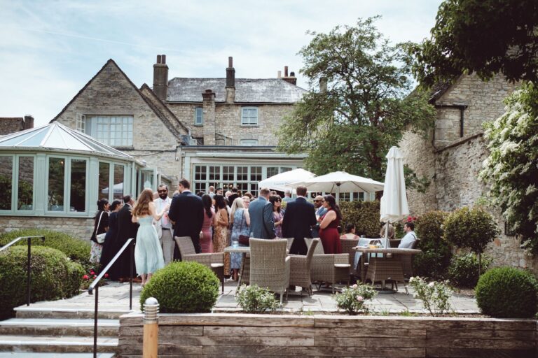 A drinks reception on the garden terrace, conservatory and hotel behind, The Bay Tree Hotel