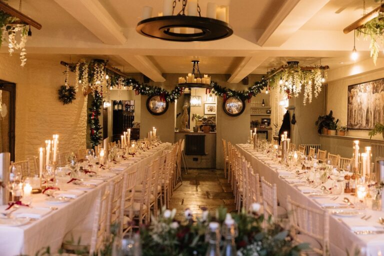 Long tables laid with candles and florals in the panelled Restaurant, The Bay Tree Hotel