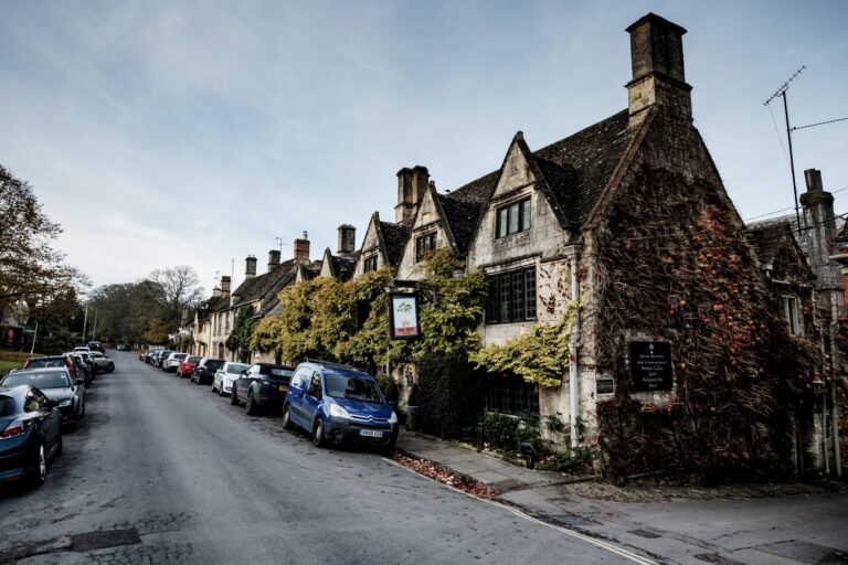 The gabled Cotswold-stone frontage on Sheep Street under autumn creeper, The Bay Tree Hotel