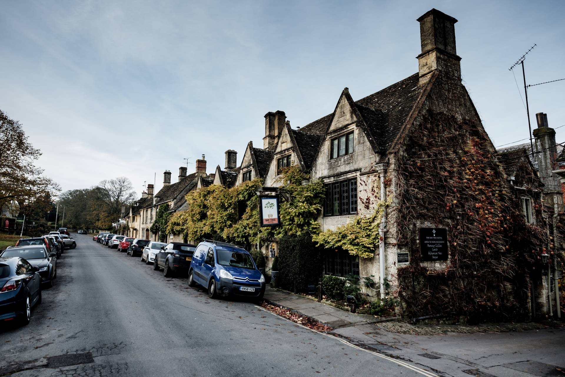 The gabled Cotswold-stone frontage on Sheep Street under autumn creeper, The Bay Tree Hotel