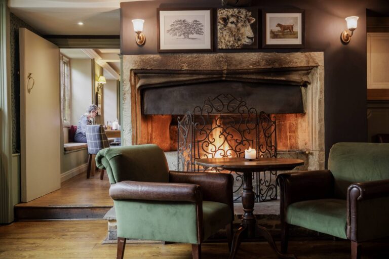 The lounge with a roaring log fire in the great stone fireplace, The Bay Tree Hotel