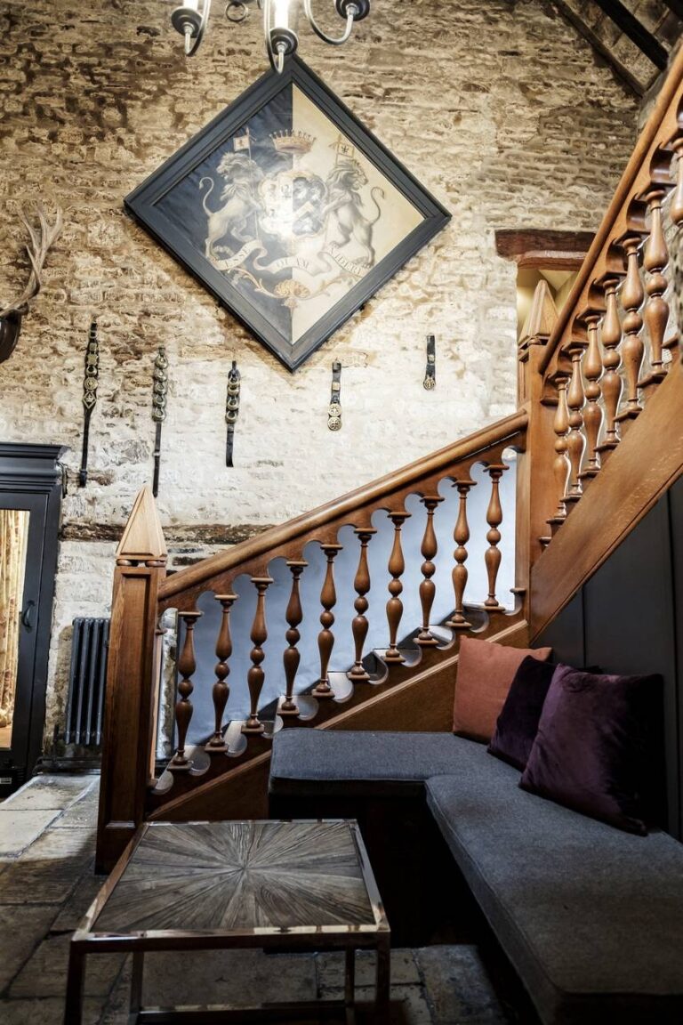 The galleried staircase with panelling and stone wall, The Bay Tree Hotel