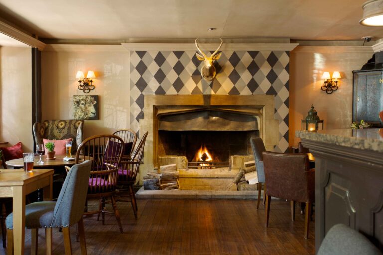 The bar with a lit fire, country-pub character and a stag over the mantel, The Bay Tree Hotel