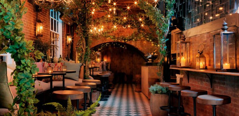 The Bloomsbury Club Bar's covered terrace, with brick arches, string lights, lanterns and climbing plants, The Bloomsbury