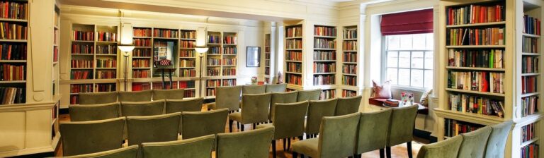 The Seamus Heaney Library set in rows of upholstered chairs facing a lectern, between floor-to-ceiling bookshelves, The Bloomsbury