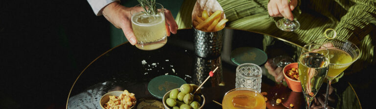 Cocktails, olives and bar snacks served on a dark marble table, The Bloomsbury