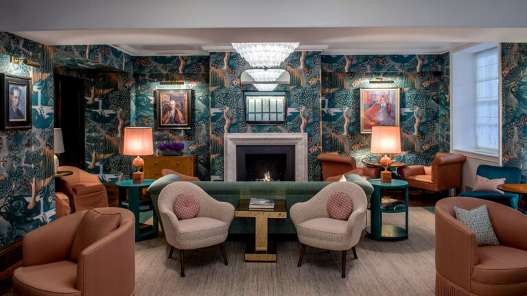 A lounge with a marble fireplace, painted-landscape wallpaper, portraits and velvet armchairs, The Bloomsbury
