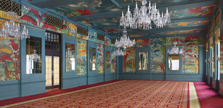 George V Hall empty, showing its lakeside wallpaper of tropical plants and animals, painted ceiling and crystal chandeliers, The Bloomsbury