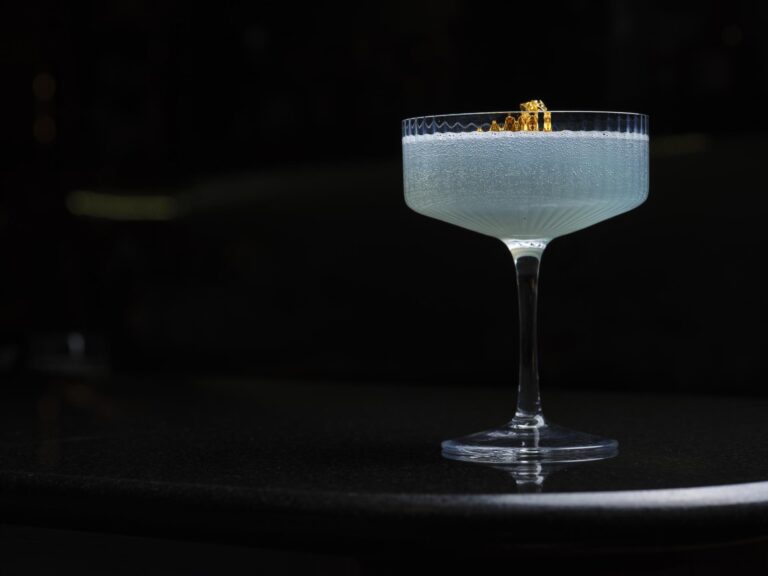 A pale blue cocktail in a coupe, finished with gold leaf, The Chelsea Harbour Hotel
