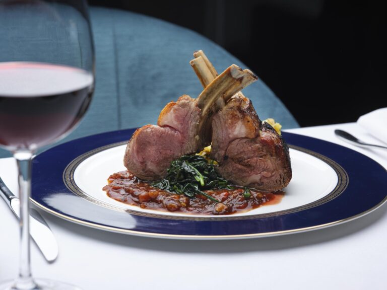 Spiced rack of lamb on greens and a tomato sauce, with a glass of red wine, The Chelsea Harbour Hotel