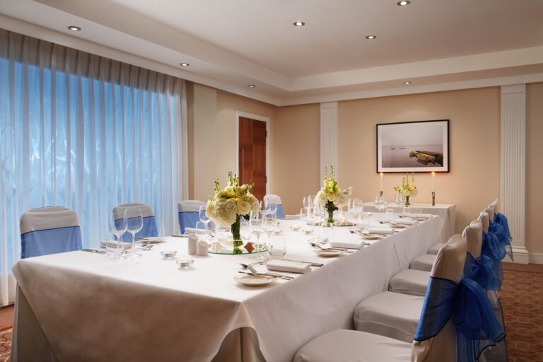 The Private Dining Room set with a long table, white flowers and candles for a small dinner, The Chelsea Harbour Hotel
