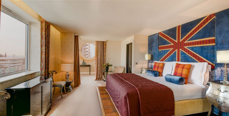 The Kings Penthouse Suite bedroom, a Union Jack headboard wall and a window over the city, The Chelsea Harbour Hotel
