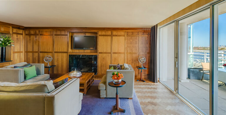 The Kensington Penthouse Suite living room with a fireplace and a balcony over the skyline, The Chelsea Harbour Hotel