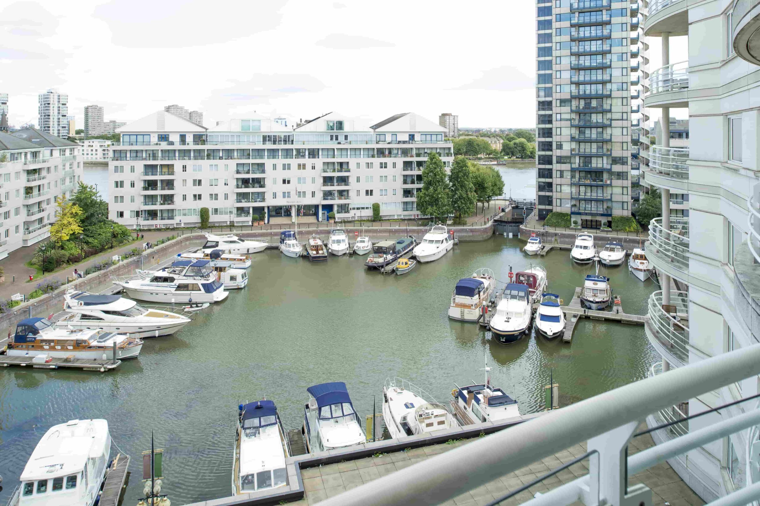 Chelsea Harbour marina seen from a hotel balcony, motor yachts berthed below the apartment blocks, The Chelsea Harbour Hotel