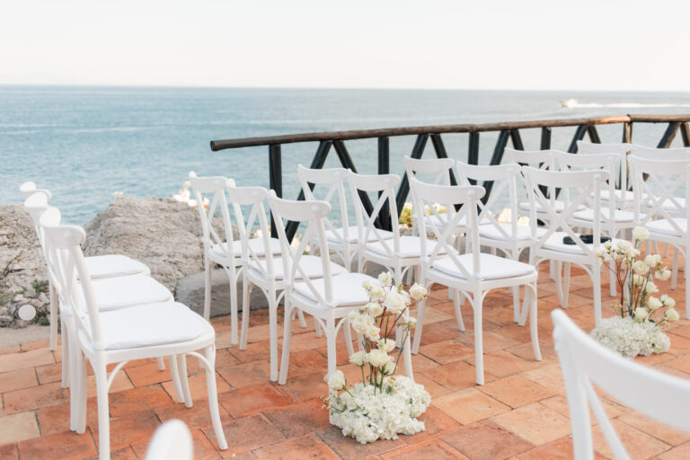 White chairs and flowers set for a clifftop ceremony, Torre La Cerniola, Amalfi Coast, The Dream Wedding Lab