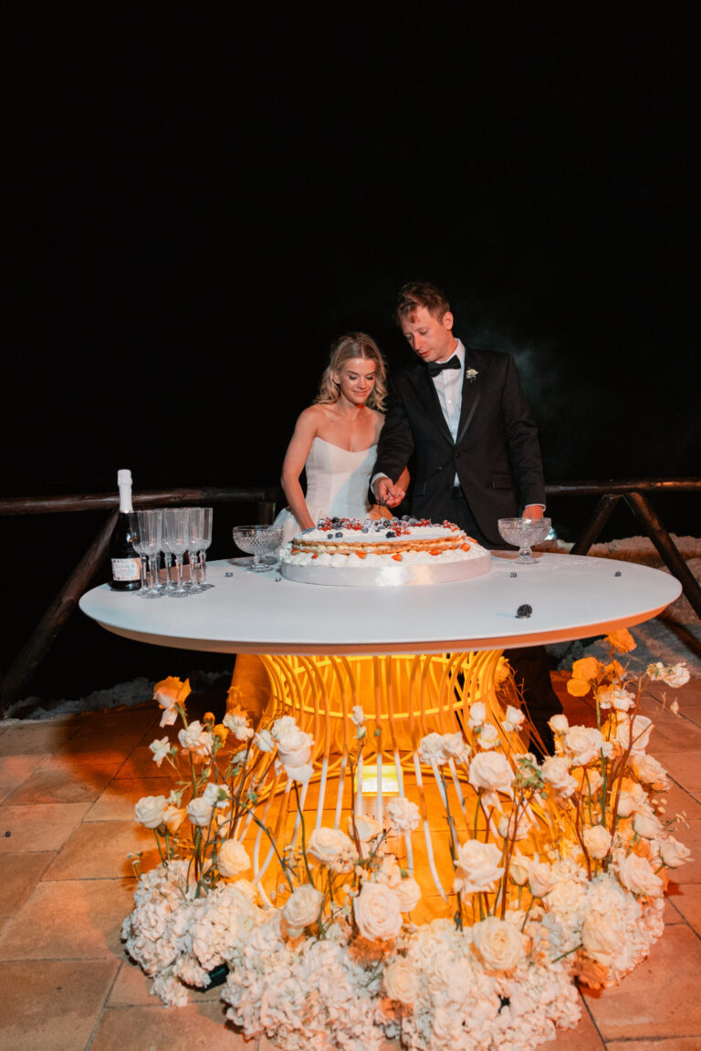 Cake table banked with white flowers at night, Torre La Cerniola, Amalfi Coast, The Dream Wedding Lab