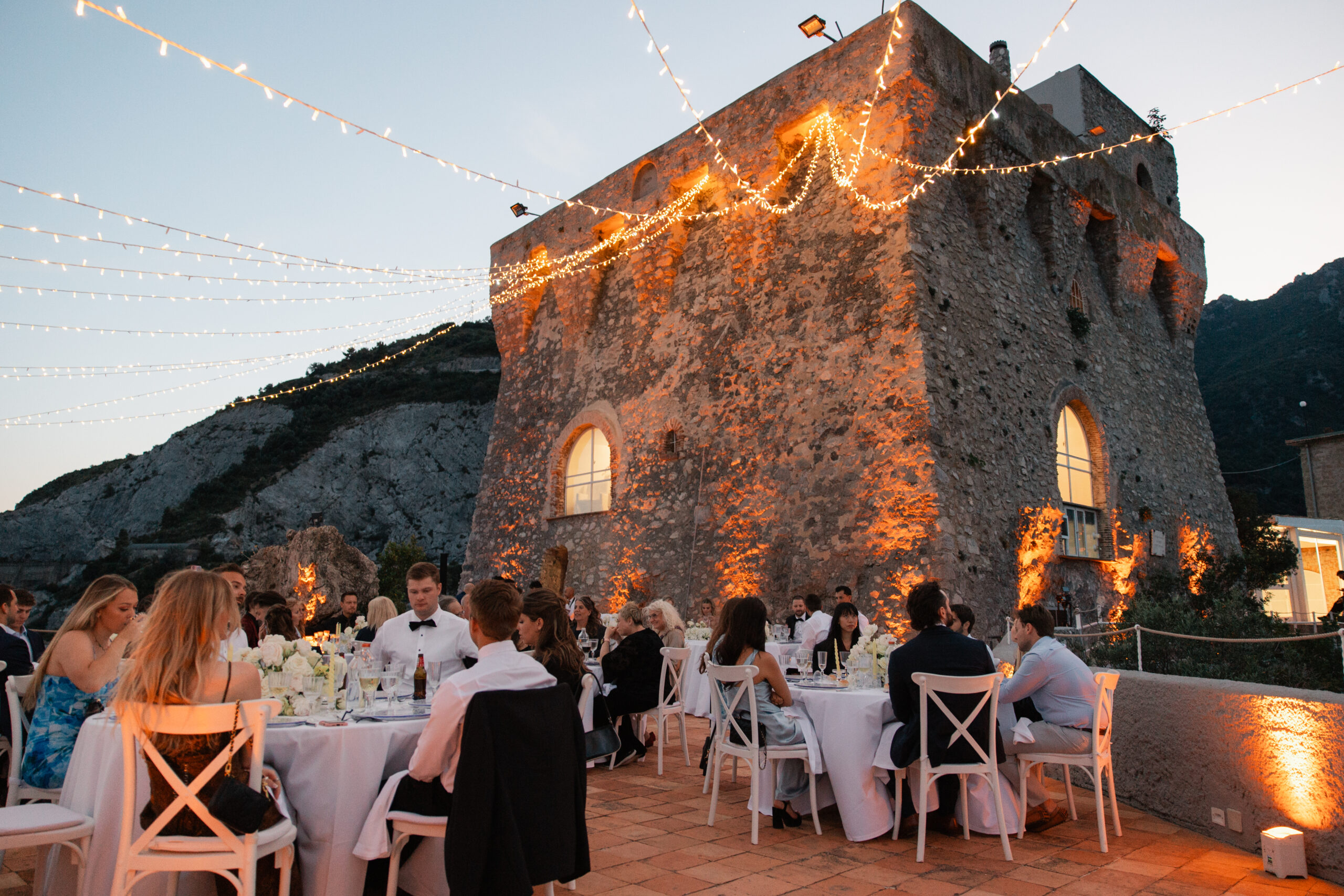 Evening reception under festoon lights beside the tower at Torre La Cerniola, Amalfi Coast, The Dream Wedding Lab
