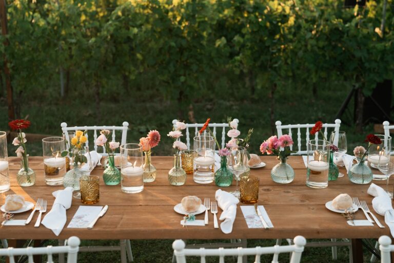 Long wooden tables with mixed flowers among the vines, Marche, The Dream Wedding Lab