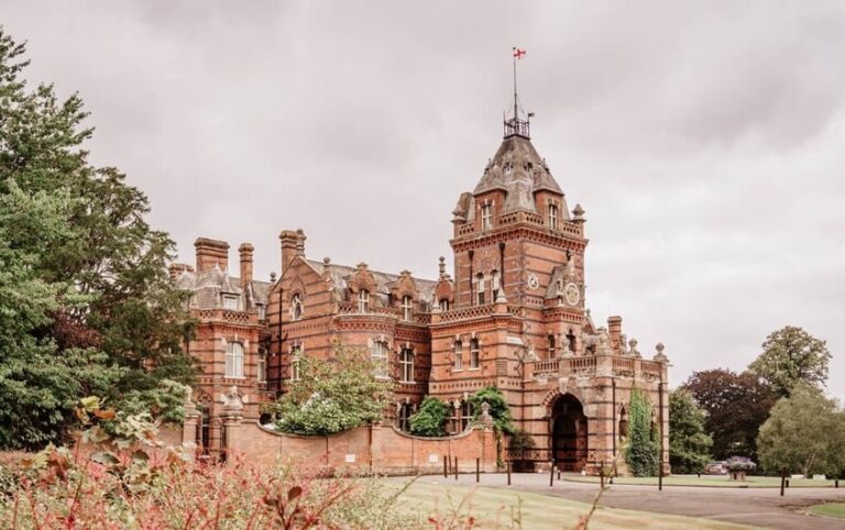 The Elvetham, a red-brick Victorian Gothic mansion, its tower and turrets under a bright sky, The Elvetham