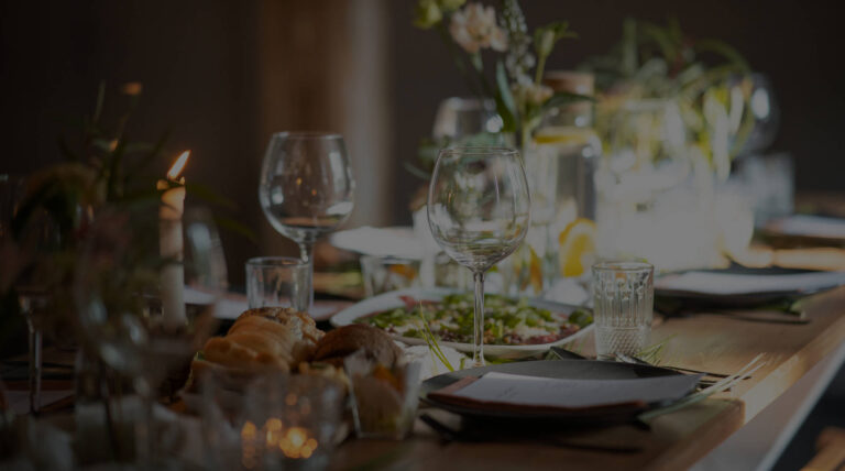 A candlelit long table with glassware and flowers at dusk, The Event Studio