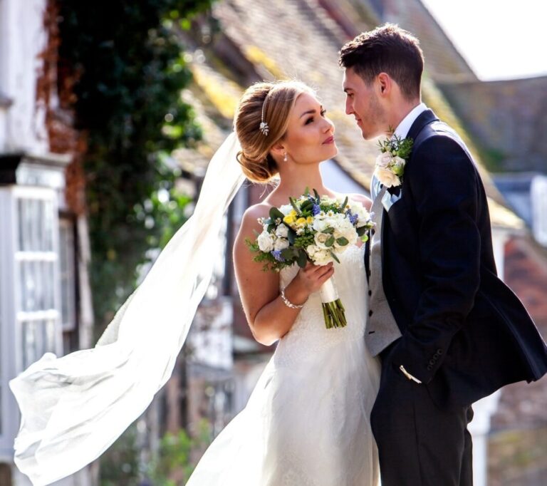A couple on a flower-framed Rye street, The George in Rye