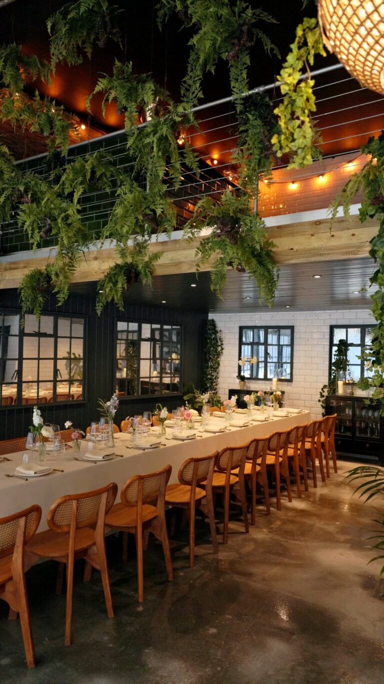 Two long tables set beneath the glasshouse roof, The Greenhouses