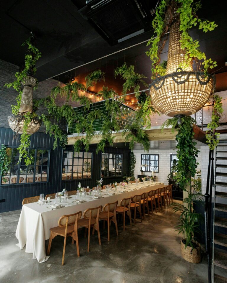 The interior hung with greenery and woven pendant lights, The Greenhouses