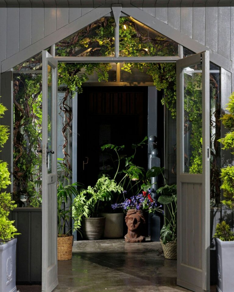 The open glasshouse doors, planting to either side, The Greenhouses